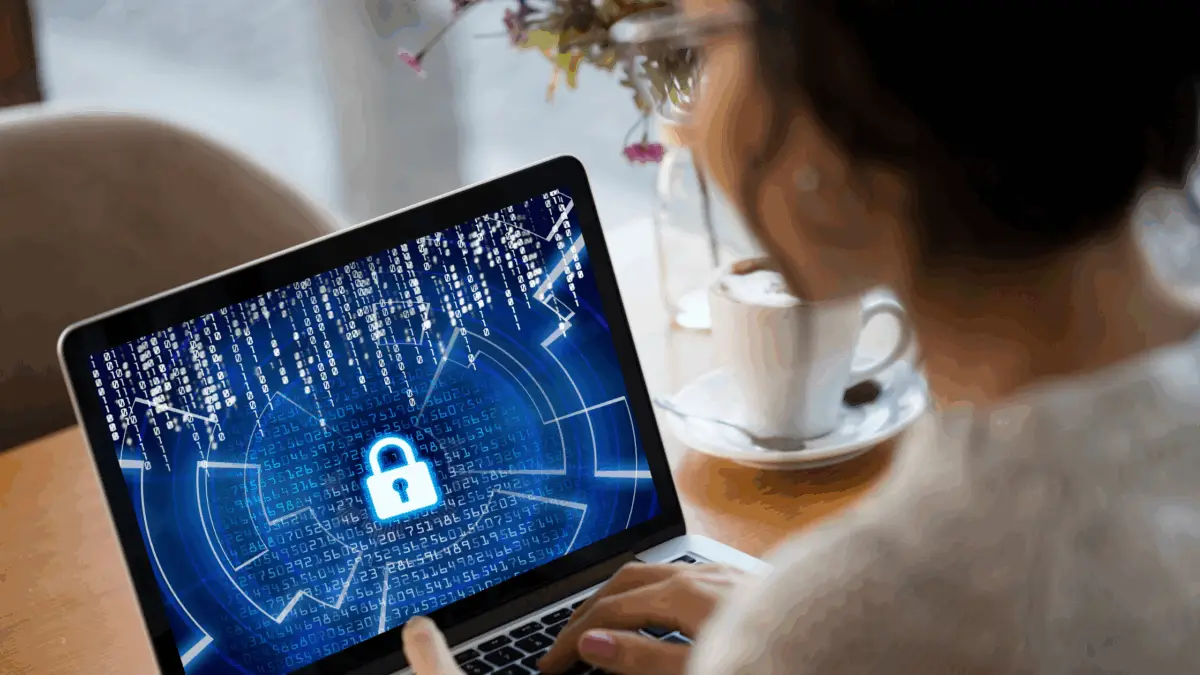 woman with laptop showing cybersecurity lock screen