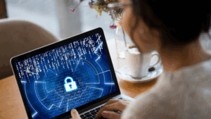 woman with laptop showing cybersecurity lock screen